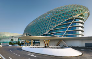 Exterior view of W Abu Dhabi hotel showcasing its architectural design with a large glass dome and curved structures 