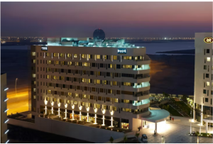  Night view of Staybridge Suites Abu Dhabi, illuminated with a beach in the background.