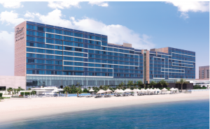 Majestic beachfront view of Fairmont Bab Al Bahr Hotel, showcasing its modern architectural design against the backdrop of blue sky. 