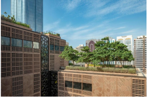 Daytime view of Courtyard by Marriott featuring upscale architecture and a green rooftop garden under a clear blue sky. 